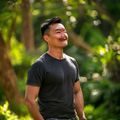 王浩然研究员，正念减压训练师，阳光开朗的男性，在户外绿色环境中站立，专注正念与情绪调节训练领域